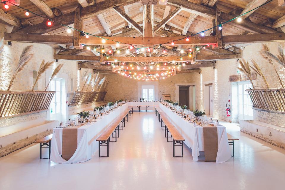 An event venue set with long tables and string lights