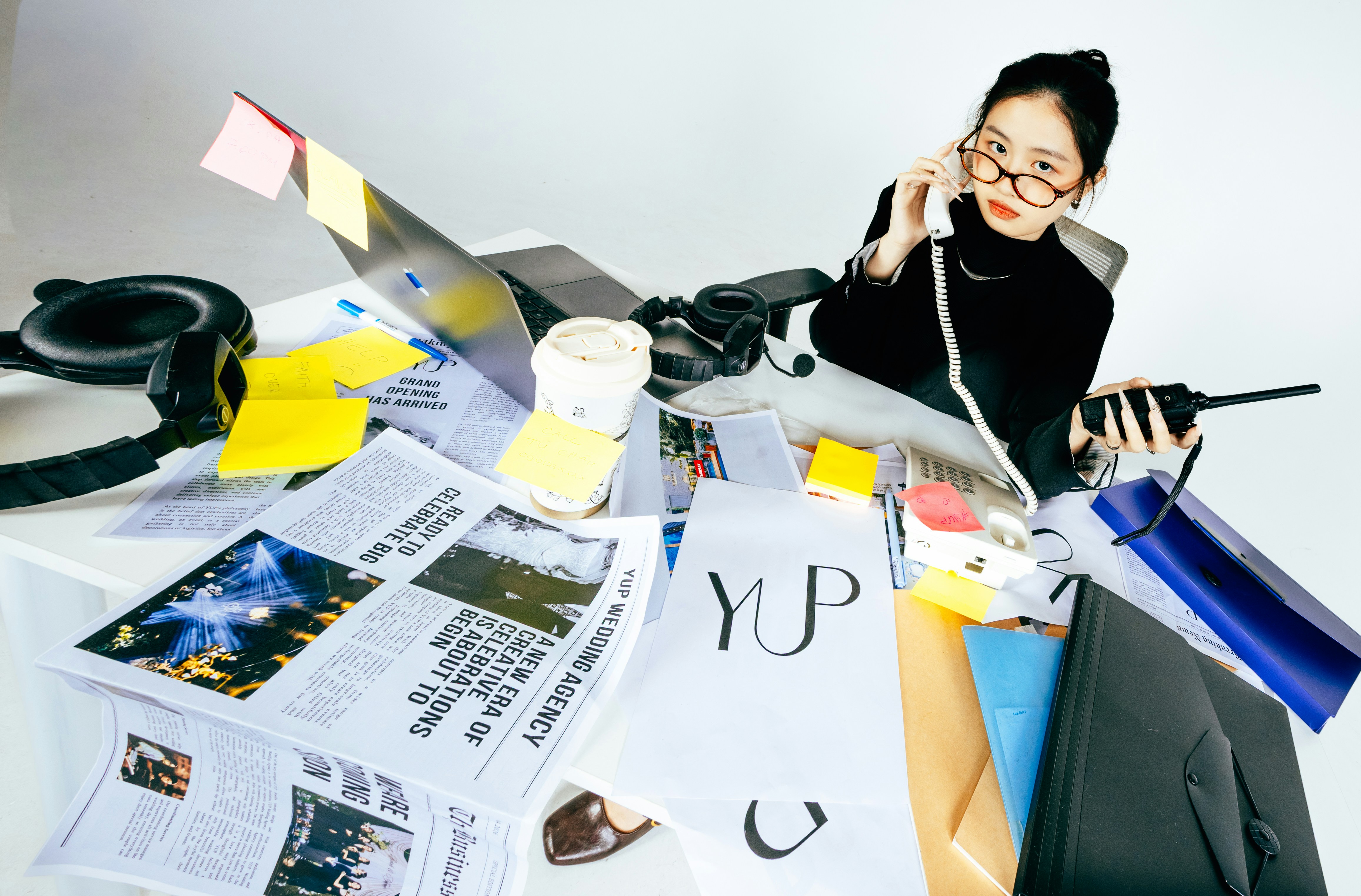 A business owner standing in front of a wall of notes, plans, and photos